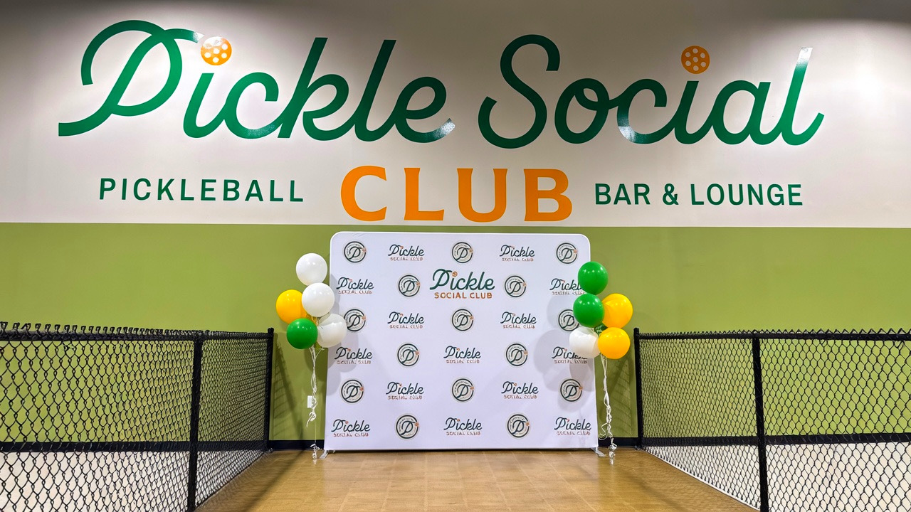 Photo board under logo in between 2 pickleball courts